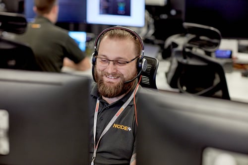 Man sitting at a desk on the phone supporting